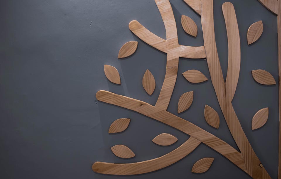 Wall decoration with the shapes of leafs made in wood at Evergreen Yoga School Cusco.